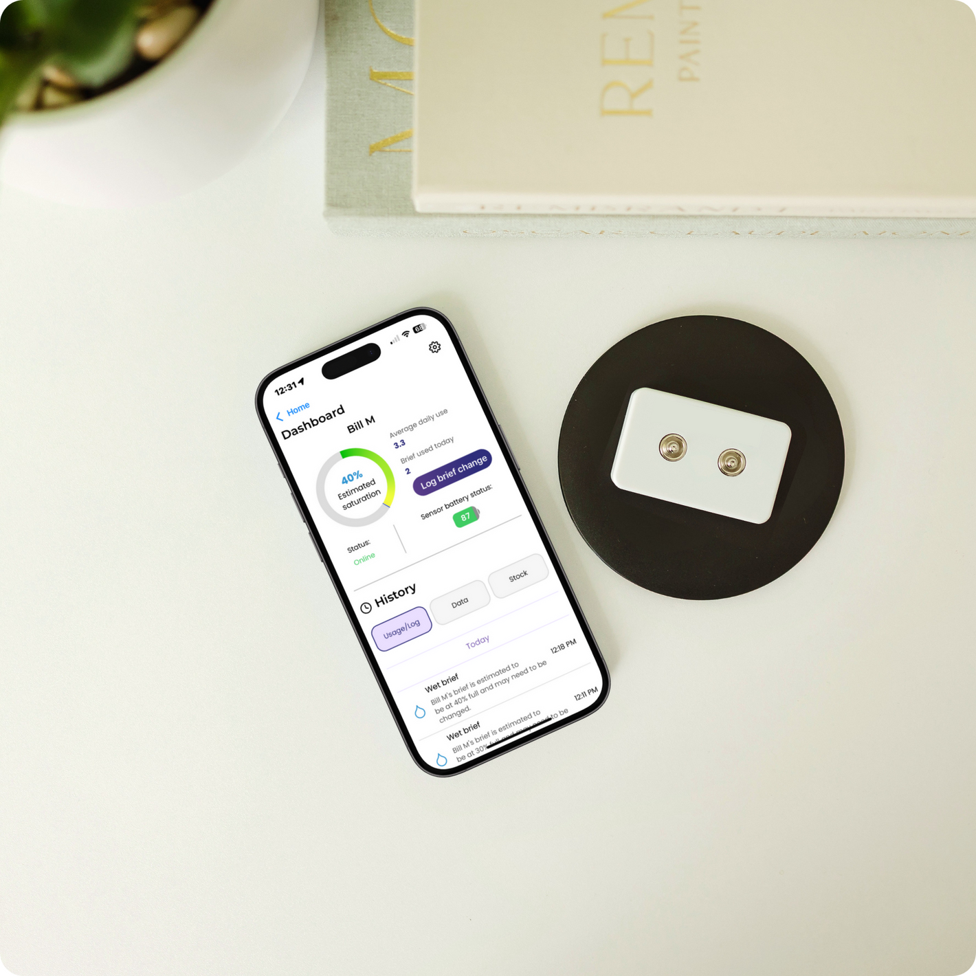 App displaying saturation level of adult diaper next to sensor on charging pad.